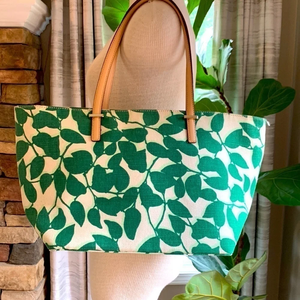 Kate Spade cream colored cloth tote with green leaf pattern.